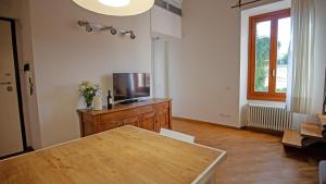 un salon avec une table et une télévision dans l'établissement Appartamento nel verde a Firenze, à Settignano