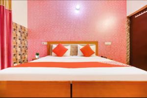 a bedroom with a large bed with red walls at Hotel Golden Height in Chandīgarh