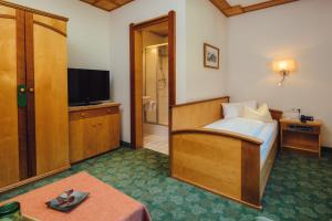 una camera d'albergo con letto e TV di Huber Hotel Tramserhof a Landeck
