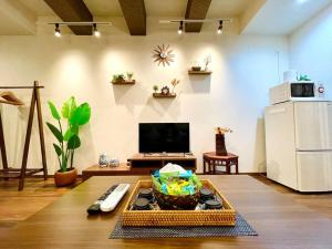 a living room with a television and a table with a bowl at 浅草桥车站徒步4分钟/秋叶原徒步12分钟/全新装修/高速wifi/网络电视 in Tokyo