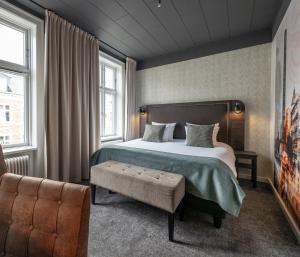 a hotel room with a bed and a chair at Hotel Mayfair in Copenhagen