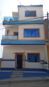 une maison blanche avec des marches bleues devant elle dans l'établissement Casas Cueva, à Tumbes