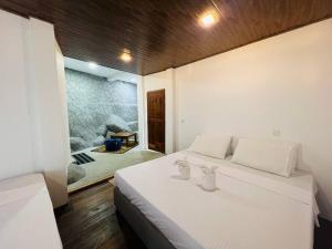 a bedroom with a white bed and a stone wall at Dolape Villa in Ella