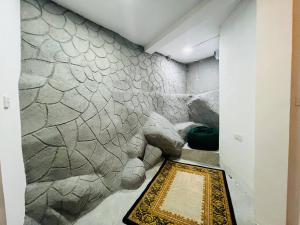 um quarto com uma parede de pedra com um tapete no chão em Dolape Villa em Ella