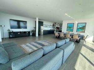 ein Wohnzimmer mit einem großen Sofa und einem Tisch in der Unterkunft Panoramic View: Lux 3 bed with heated pool in Arco da Calheta