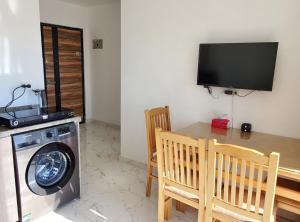 a kitchen with a washing machine and a table and chairs at Hurghada Pearl in Hurghada