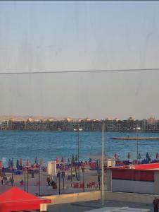 a beach with chairs and umbrellas on the water at Hurghada Pearl in Hurghada
