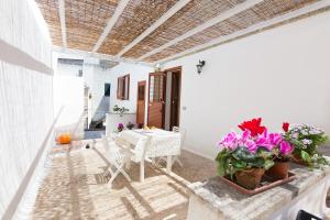 a patio with a table and chairs and flowers at Casa Lucia in Specchia +17 photos