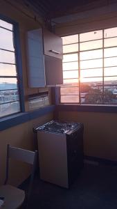 a kitchen with a stove and two windows in it at Casas Cueva in Tumbes