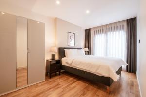 sypialnia z łóżkiem i dużym oknem w obiekcie Homie Suites - Newly Built Seaside Apartments on Bakırköy Shore w Stambule