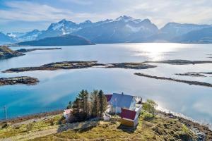 un'isola in un corpo d'acqua con montagne di Panoramic seaview cabin for two persons by the sea a Hovdan