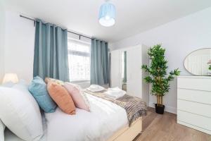 a bedroom with a bed with pillows and a window at 2-Bedroom Apartment in Greater London: Explore and Relax in Enfield