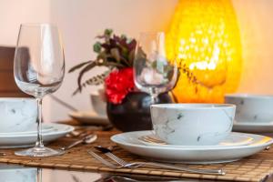 a table with two wine glasses and plates on it at 2-Bedroom Apartment in Greater London: Explore and Relax in Enfield