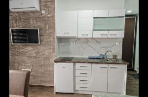 a kitchen with white cabinets and a sink at Imperial in Veliko Gradište