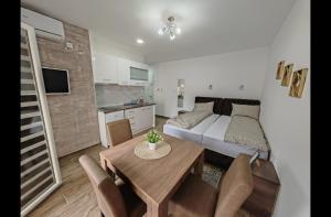 a room with a bed and a table and a kitchen at Imperial in Veliko Gradište