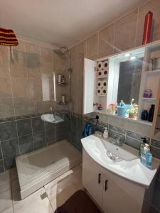 La salle de bains est pourvue d'un lavabo, d'une douche et d'une baignoire. dans l'établissement Central Izmir Delight: Cozy Alsancak Apartment, à Konak