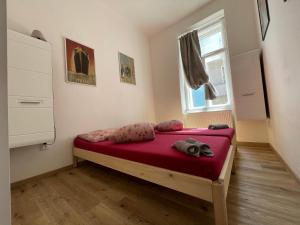sypialnia z łóżkiem z czerwoną pościelą i oknem w obiekcie Vintage Apartment Ostrava center city w Ostravie