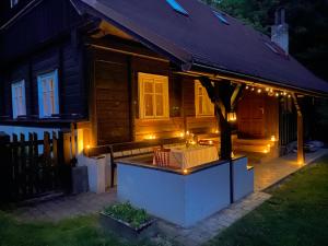 a house with lights on the front of it at night at Chaloupka v Českém Ráji in Semily