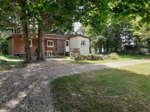 a cabin in the woods with a tree at Camping Domaine Papillon in Reyrevignes +16 photos