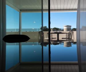 - une vue sur la piscine depuis une fenêtre en verre dans l'établissement La Suite Matera Hotel & Spa, à Matera