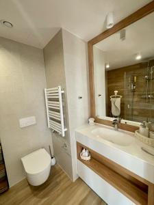 a bathroom with a tub and a toilet and a sink at Apartament Marina View in Darłowo