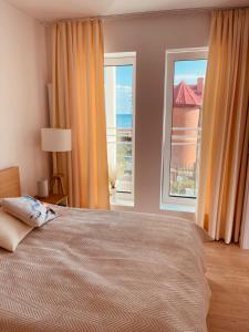 a bedroom with a large bed and a large window at Apartament Marina View in Darłowo