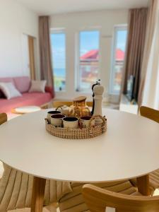 a white table with a tray of dishes on it at Apartament Marina View in Darłowo