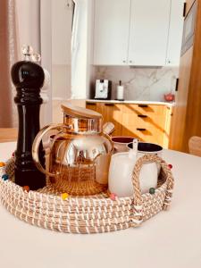 a wicker basket with a tea pot and a candle at Apartament Marina View in Darłowo