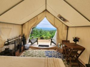 a tent with a bed and a table in a room at Tentrr Signature Site - Mountain View in Buckfield Maine in Paris