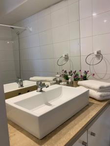 y baño con lavabo blanco y espejo. en B&M Alquiler diario, en Santiago