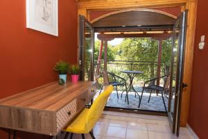 een kamer met een houten tafel en een balkon bij Cheerful artist villa in the genuine part of Evia Greece in Kastríon