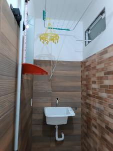 baño con lavabo y sombrilla roja en Studio Mar & Sol en Armacao dos Buzios
