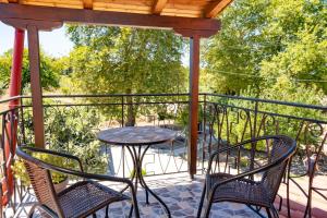een patio met een tafel en stoelen op een balkon bij Cheerful artist villa in the genuine part of Evia Greece in Kastríon