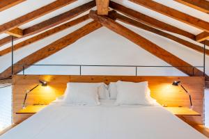 uma cama num quarto com tectos em madeira em Agroturismo Filicumis em Lloseta