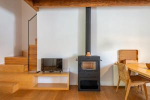 a wood stove in a room with a table and a tv at Agroturismo Filicumis in Lloseta