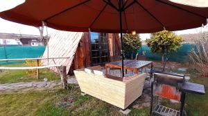 a table and an umbrella with a table and a bench at Tiny Garden House in Prague