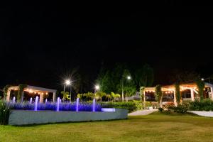 a fountain in the middle of a park at night at Hotel Fazenda M1 in Águas de Lindoia