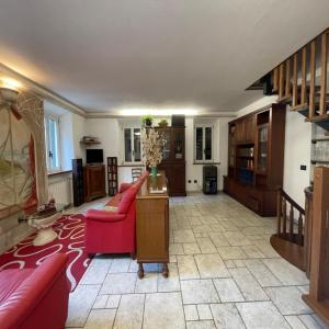 ein Wohnzimmer mit einem roten Sofa und einem Tisch in der Unterkunft Casa Garfagnana in Fornaci di Barga