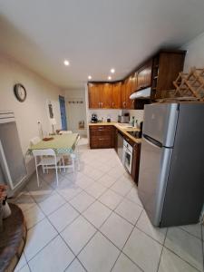 a kitchen with a table and a stainless steel refrigerator at Riverside apartment in Sospel
