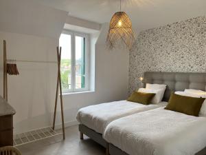 sypialnia z 2 łóżkami i oknem w obiekcie Le Loft de Babolène w mieście Villefranche-de-Rouergue