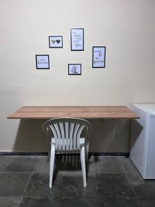 a desk with a chair and pictures on the wall at Pousada Sintramog in Bertioga