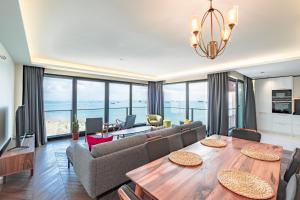 Homie Suites - Newly Built Seaside Apartments on Bakırköy Shore في إسطنبول: غرفة معيشة مع طاولة طعام وغرفة معيشة مع المحيط