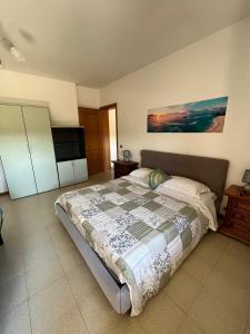 a bedroom with a bed and a flat screen tv at Il giardino degli Ulivi house in Ortona