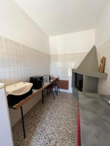 a kitchen with a table and a stove in a room at Il giardino degli Ulivi house in Ortona