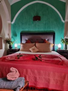 sypialnia z dużym łóżkiem i zieloną ścianą w obiekcie Casa del Sol Marrakech w Marakeszu