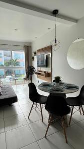 ein Wohnzimmer mit Esstisch und Stühlen in der Unterkunft Muro Alto Condomínio Clube Apto 219 in Ipojuca