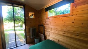 um quarto com uma parede de madeira e uma janela em Orchard Hideaways em Penrith