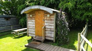 a wooden out house with a door in the grass at Orchard Hideaways, Penrith, The Lake District in Penrith