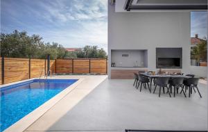 a patio with a dining table and a swimming pool at Villa Activia in Sveti Filip i Jakov