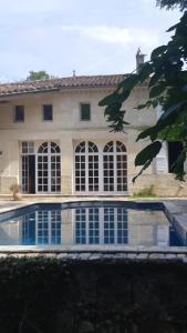 a large house with a swimming pool in front of it at Buisson gîte et chambre d'hôte in Laruscade